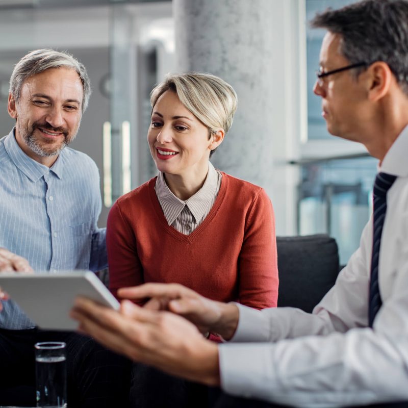 happy-mid-adult-couple-using-touchpad-with-their-financial-consultant-in-the-office-.jpg happy-mid-adult-couple-using-touchpad-with-their-financial-consultant-in-the-office-.jpg